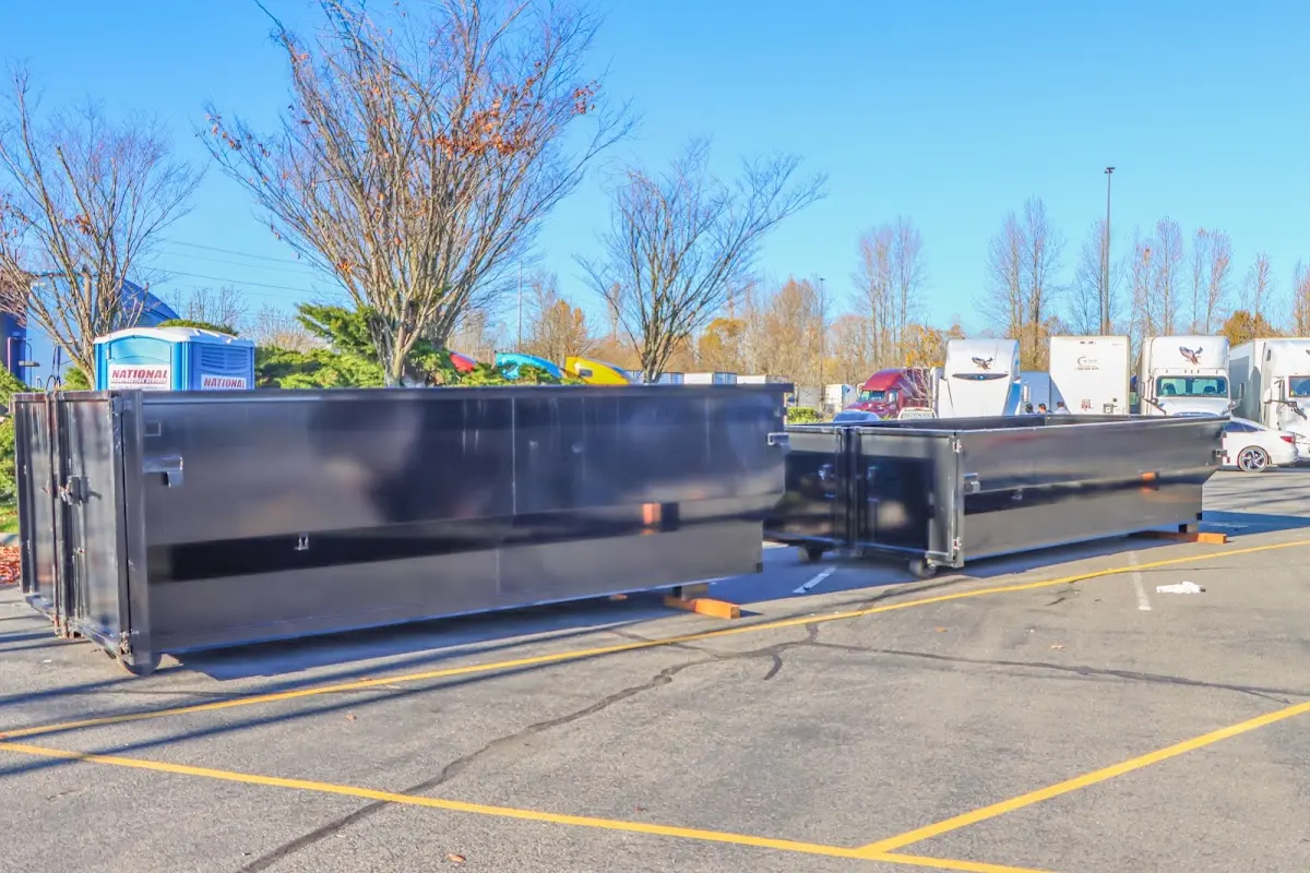 Professional dumpster rental service with roll-off container on residential driveway in Eden